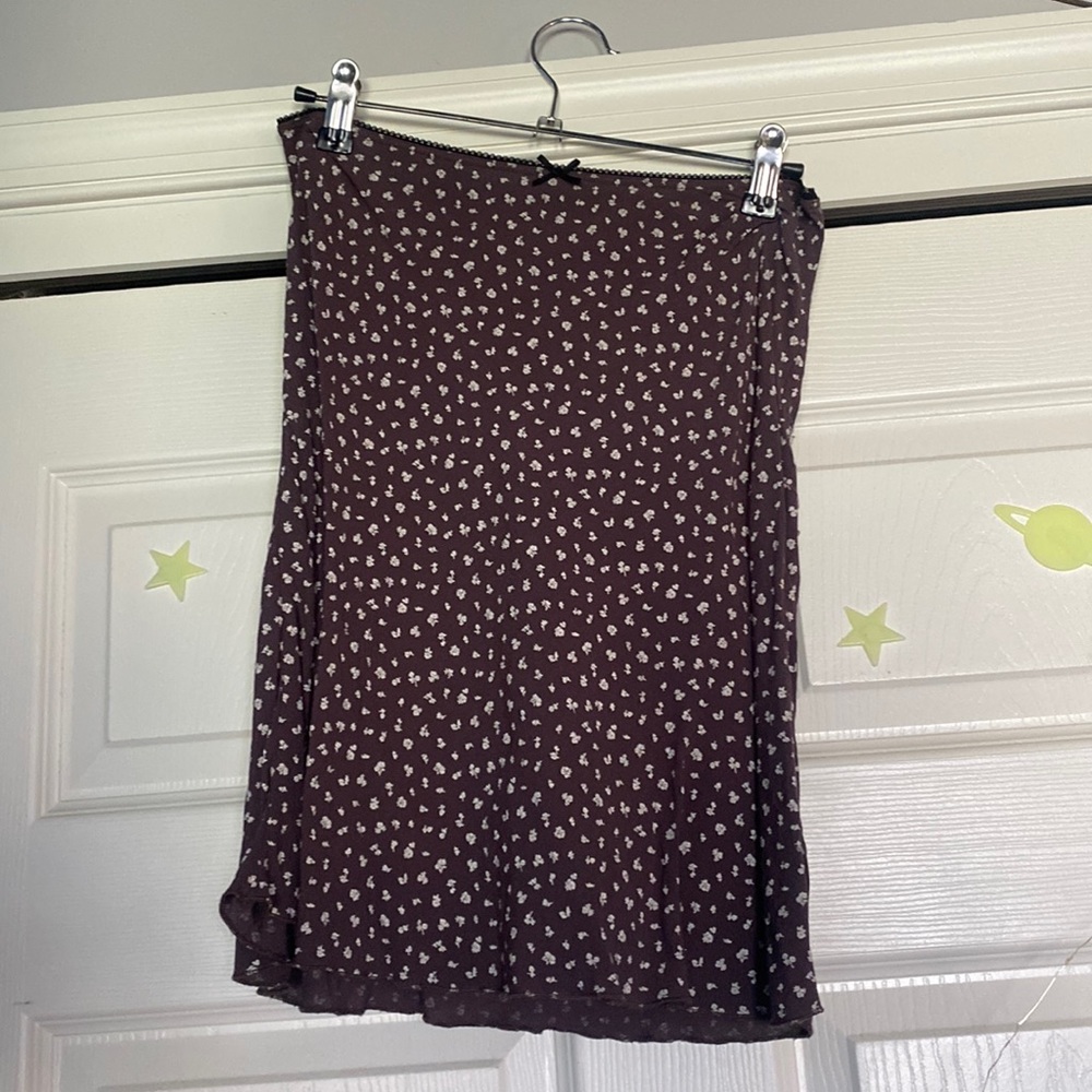 This is a brown Brandy Melville skirt with cream colored flowers.